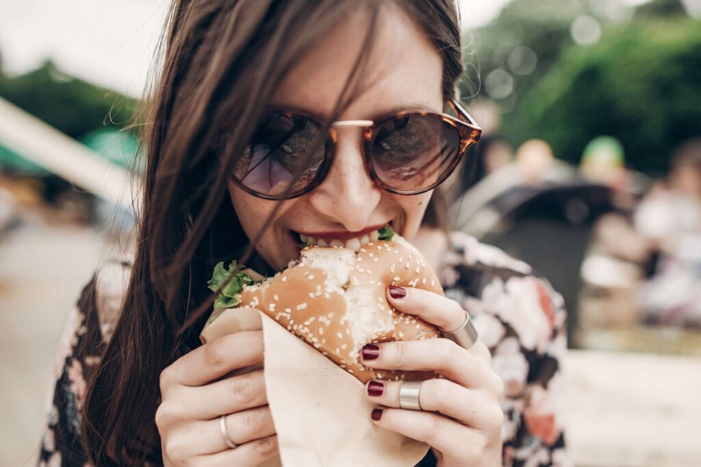 A woman eating a burger in Fall In Hawaii​.