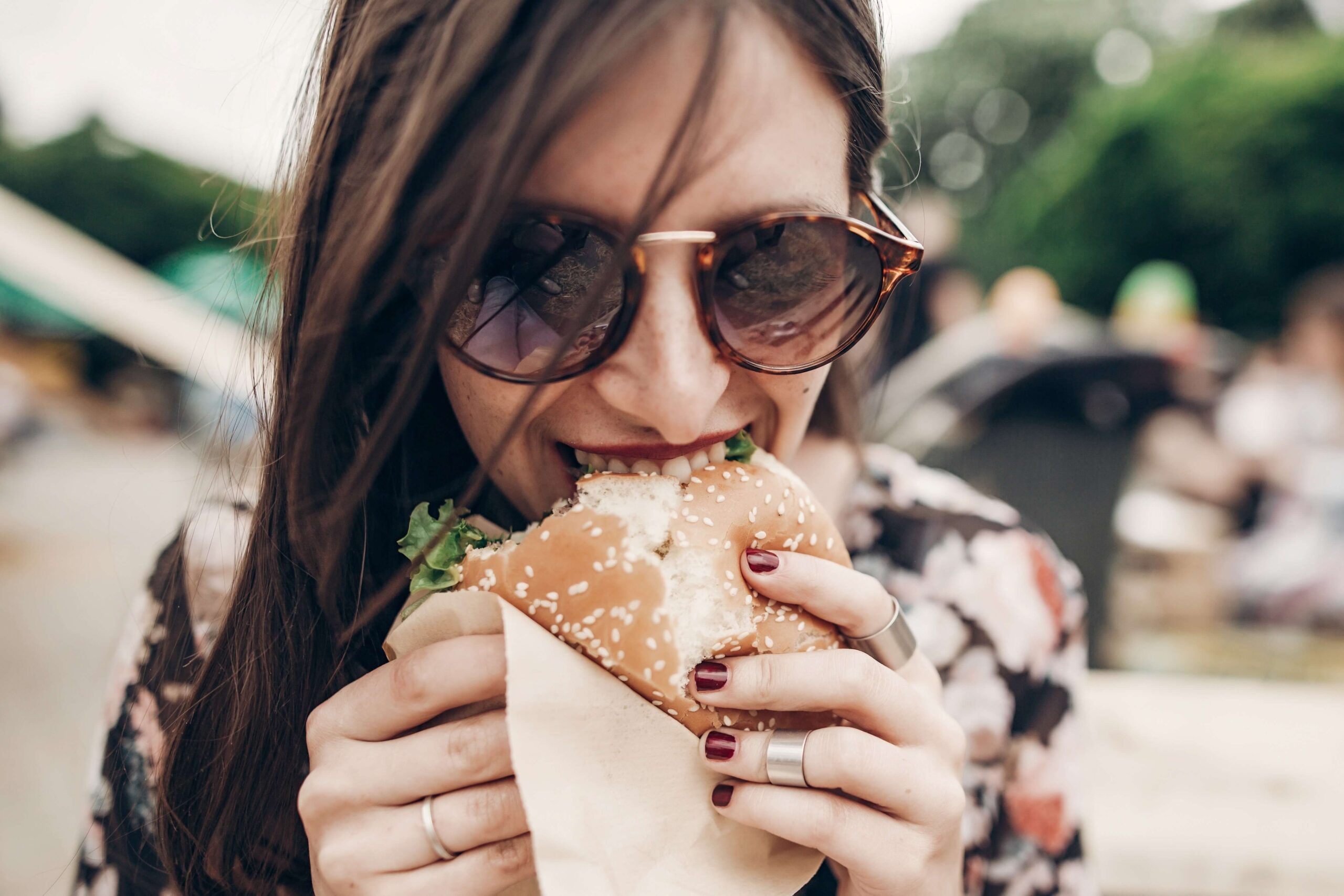 A woman eating a burger in Fall In Hawaii​.